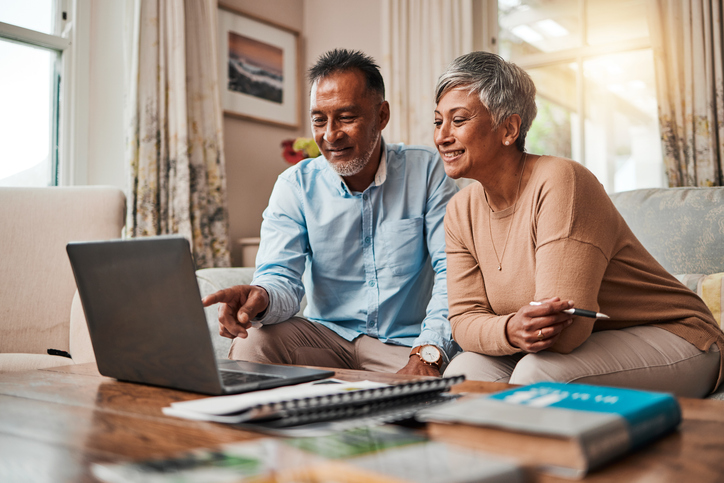 A senior couple reviewing their retirement plan options online.
